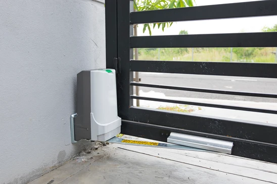 Extérieur résidentiel avec portail coulissant automatisé en cours d'installation