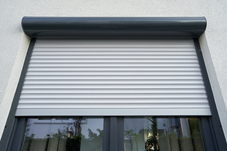 Façade extérieure d'habitation avec volet roulant moderne partiellement ouvert