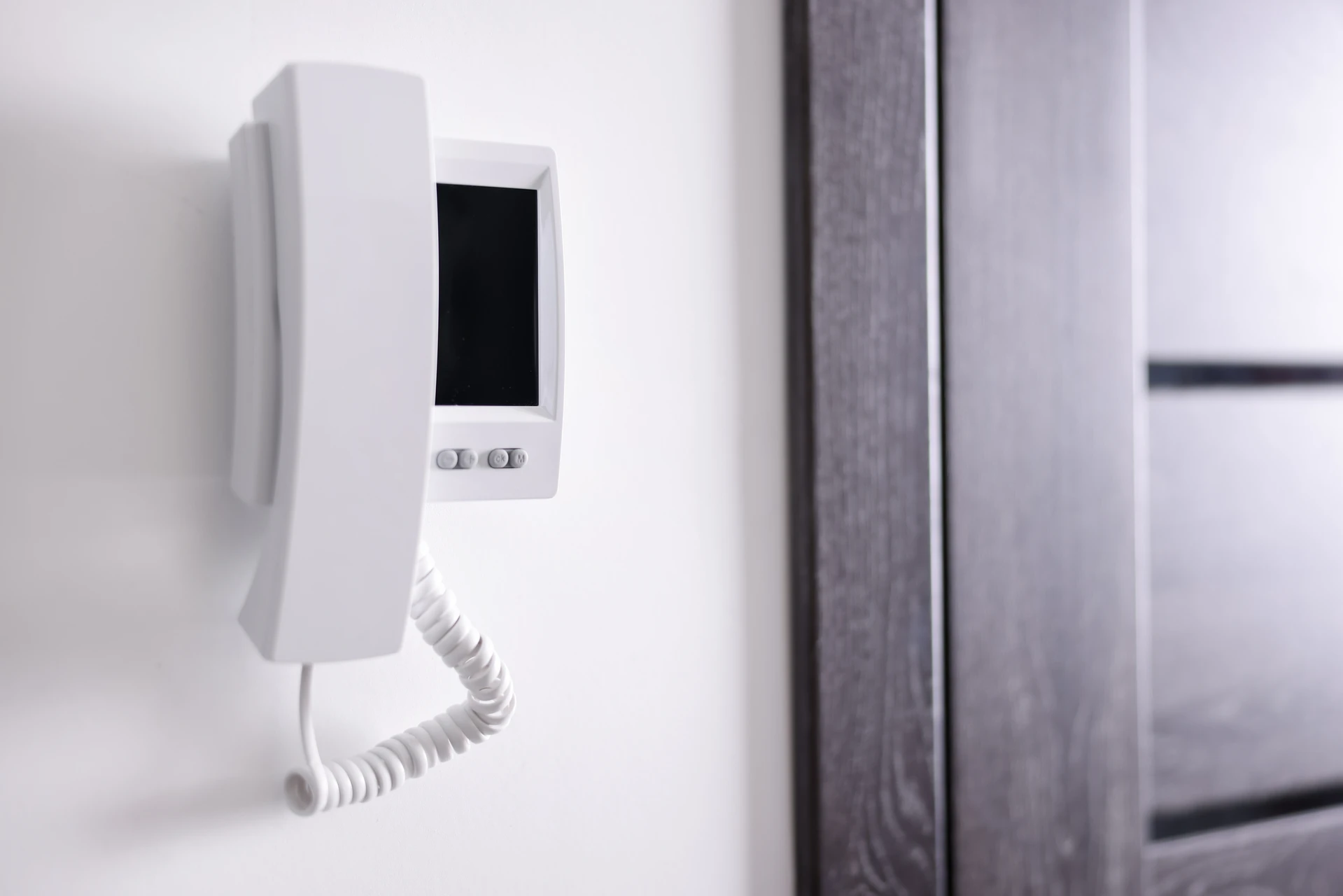 Système d'interphone vidéo numérique installé sur portail métallique gris à barreaux verticaux