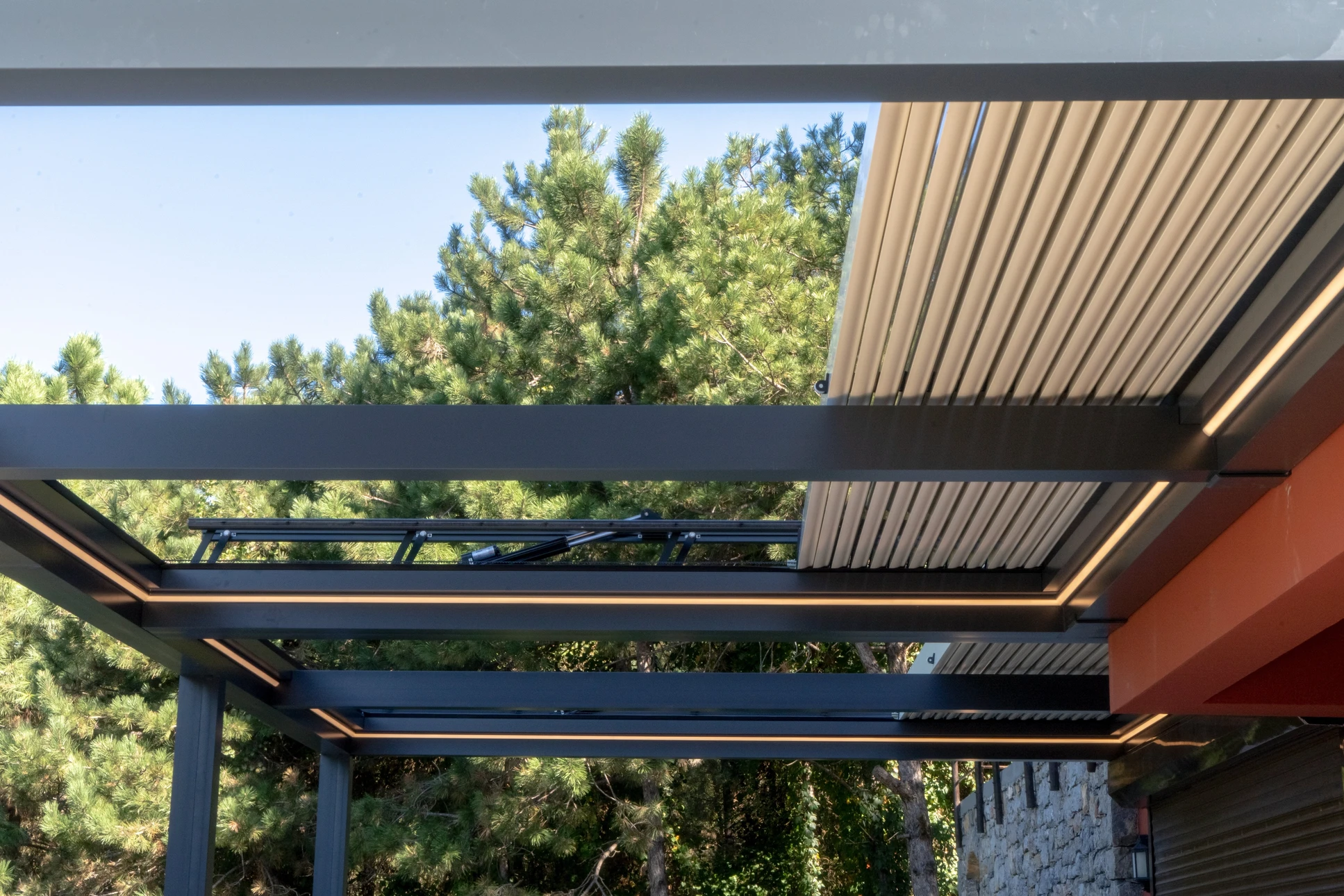Pergola bioclimatique moderne avec lames orientables en aluminium blanc partiellement ouvertes