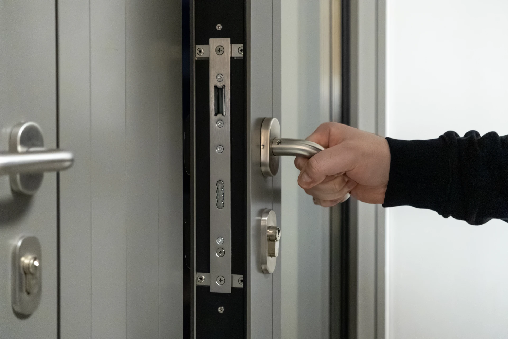 Un serrurier répare une serrure de porte d'entrée en bois vernis